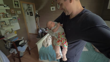 padre acurrucando a su hija en casa y mirándola con amor