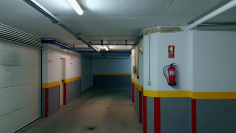 large empty building hallway with closed doors gates illuminated led lamps.