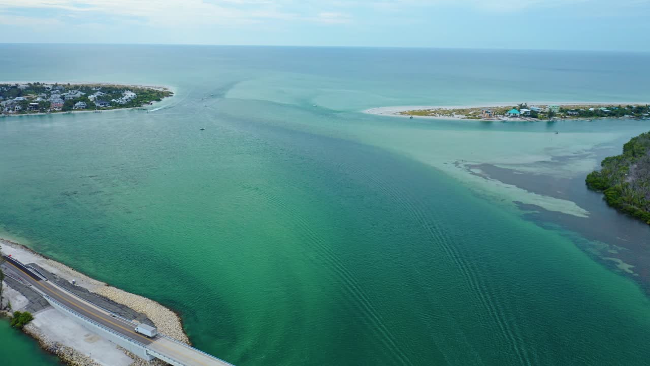 Turquoise water flows through Stump Pass Inlet toward the Gulf of Mexico beside Manasota Key on Florida’s Gulf Coast, highlighting sandbars, tidal channels, and sweeping color across the inlet