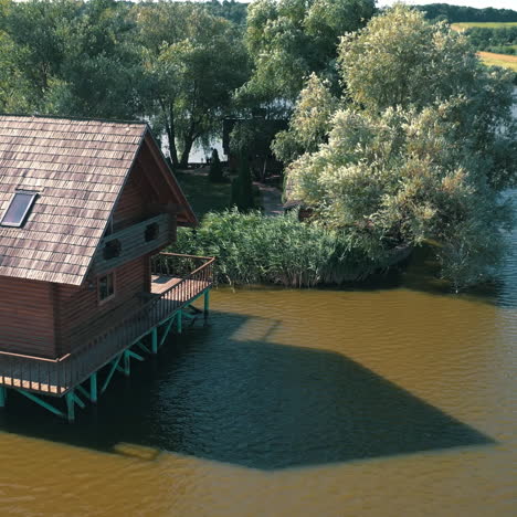 beautiful natural landscape on the island situated on river. aerial shot of a wooden house on island on lake on a sunny day.