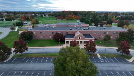 aerial truck shot of small elementary school in autumn