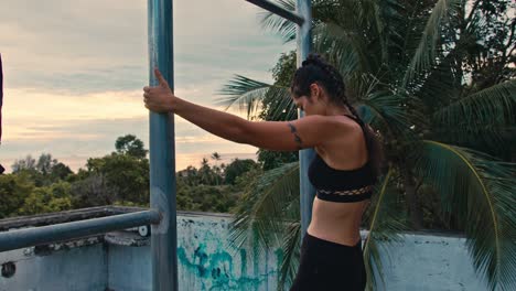 woman exercising on rooftop at sunset