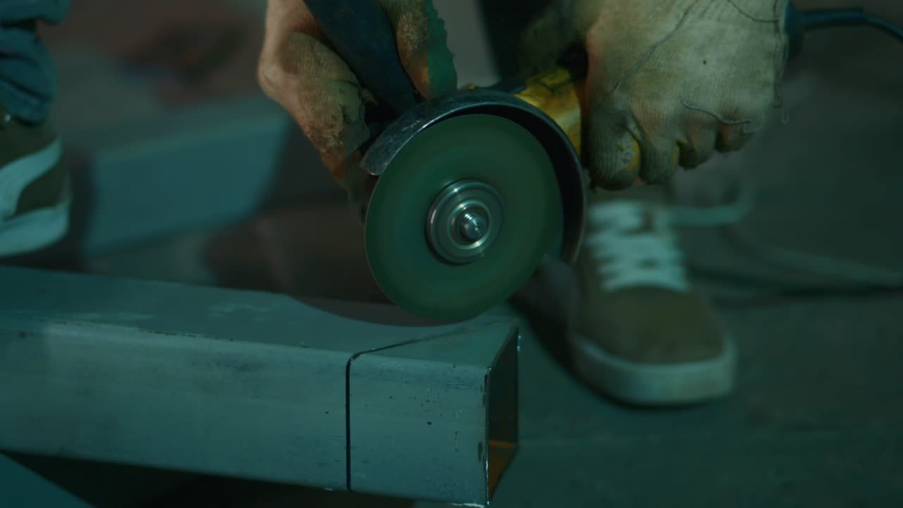 Close-Up of Worker Using Angle Grinder to Cut Metal with Sparks