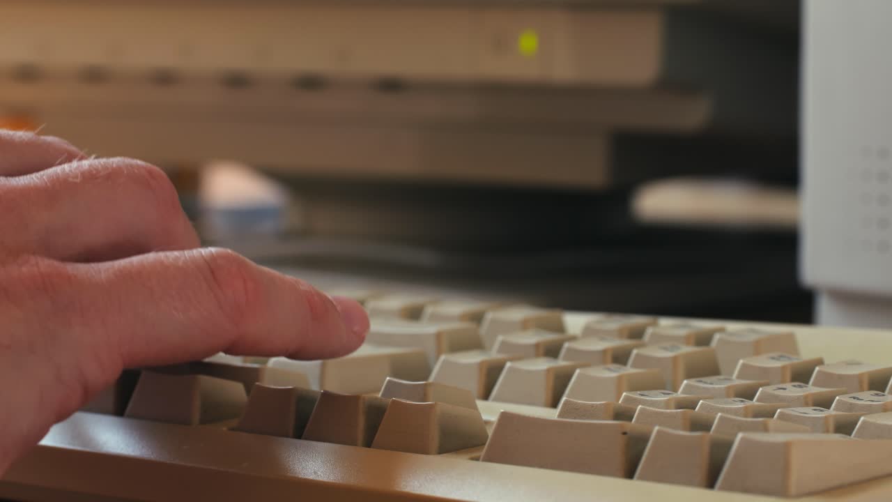 Man working and gaming on retro computer PC, IT engineer with vintage computer at home, using old fashion technology, close up of retro setup.