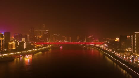 aerial view of chongqing’s dongshuimen bridge at night, illuminated with vibrant lights. the yangtze river reflects the glowing city skyline, capturing the dynamic beauty of this chinese metropolis.