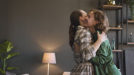 portrait of two sisters hugging each other at home and then smiling at camera