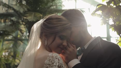 um casal feliz a beijar-se numa estufa.