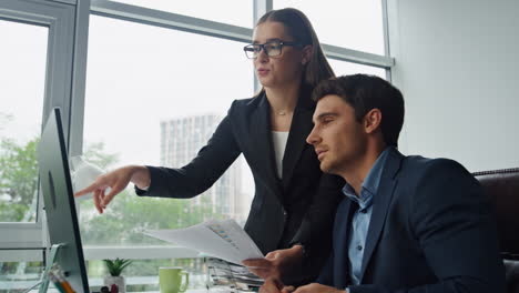 Colleagues-discussing-documents-together.-Office-team-checking-data-in-computer