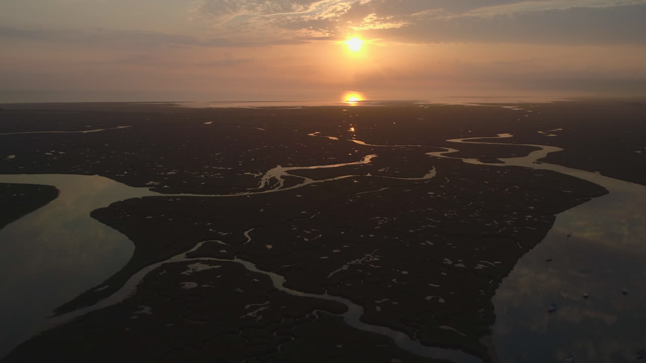 drone disparó sobre salt marsh y creek en marea alta con un impresionante amanecer y hermosos reflejos en wells-next-the-sea north norfolk, reino unido, costa este