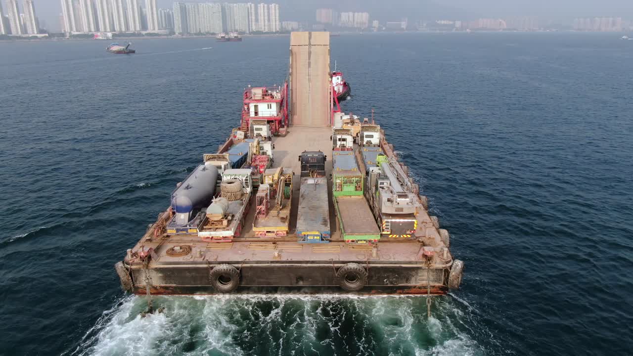 홍콩 만의 예인선으로 항구로 끌려간 콘크리트 믹서 트럭을 실은 바지선, 공중 전망