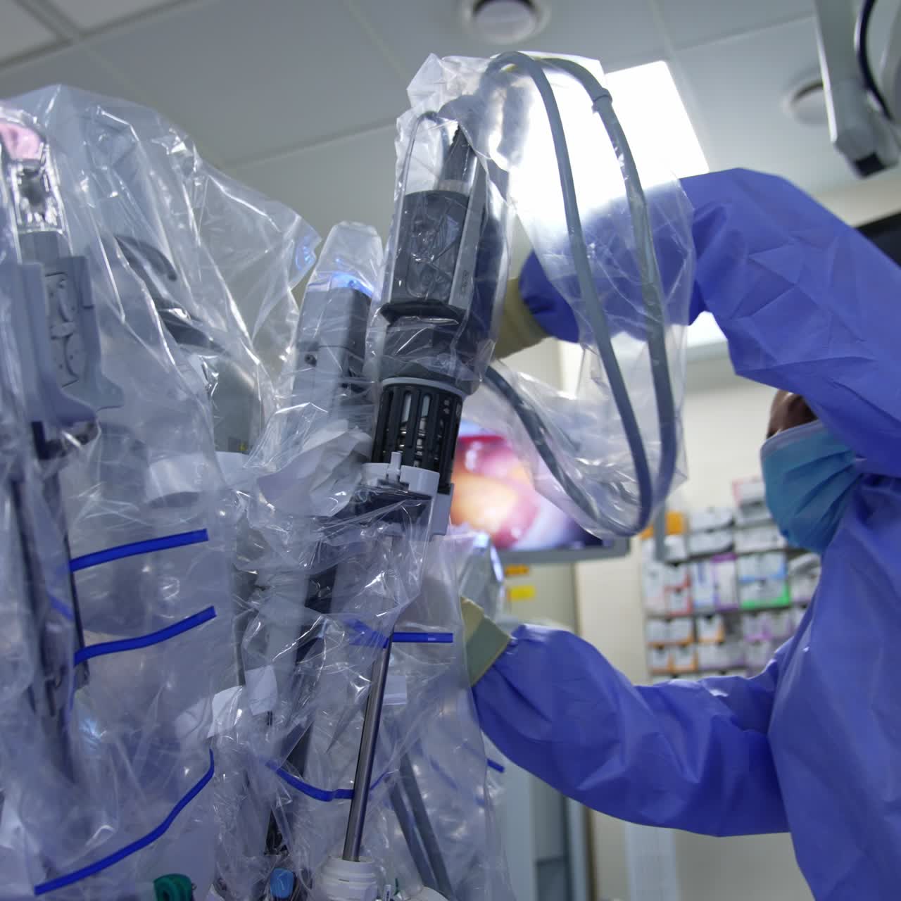 Lady in uniform and mask works with the robotic equipment. Medic checks the readiness of technological robot to perform surgery