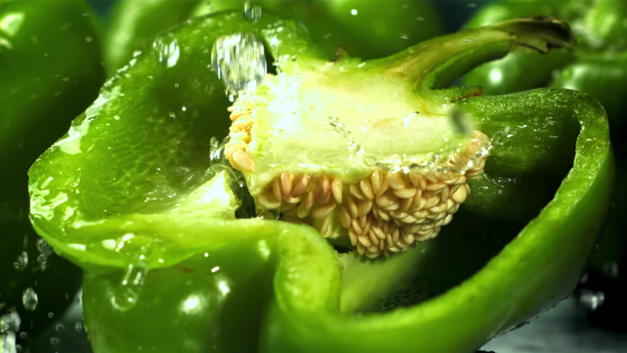 Close-up de Água Salpicando um Pimentão Verde Fresco