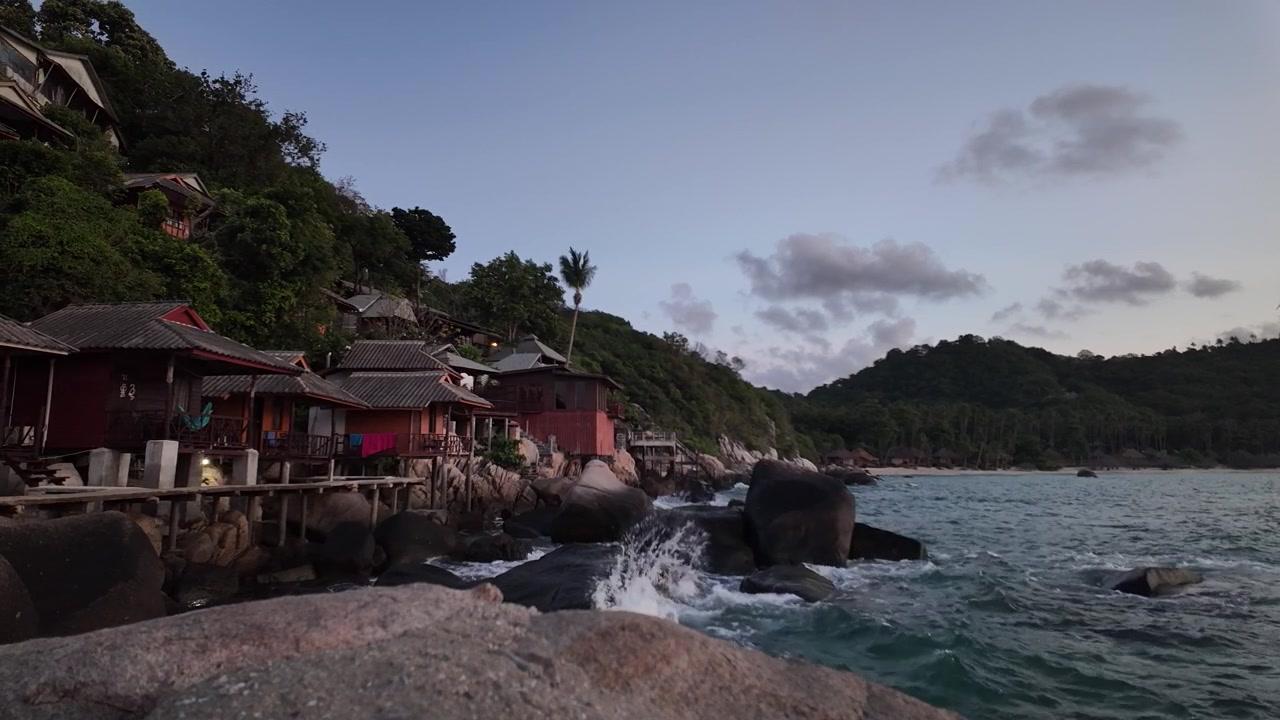 Paalumajat Shark Bayn lahden rannalla auringonnousun aikaan Koh Taon saarella, Thaimaassa. Laajakuva.