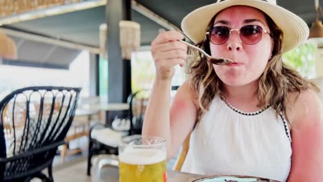 summer refreshment: woman drinks cold beer in greece