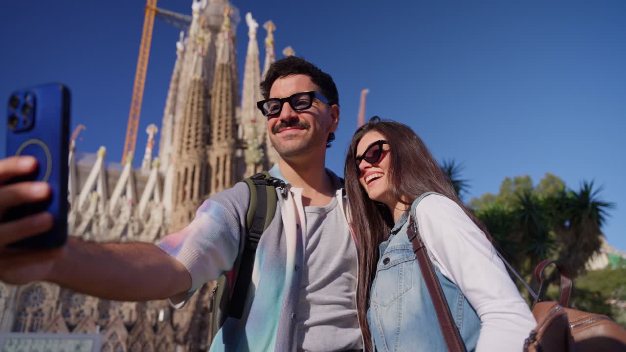 Coppia felice che si scatta un selfie di fronte alla Sagrada Familia