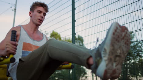 closeup exhausted sportsman training in sport playground. guy practicing workout