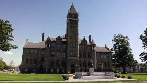 Hackley-Administration-building-in-Muskegon,-Michigan-with-gimbal-video-walking-forward-through-trees