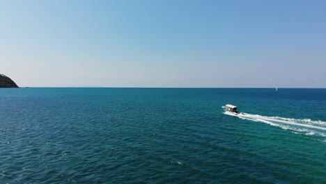 Flying-with-a-drone-behind-a-motor-boat-in-Koh-Phangan,-Thailand