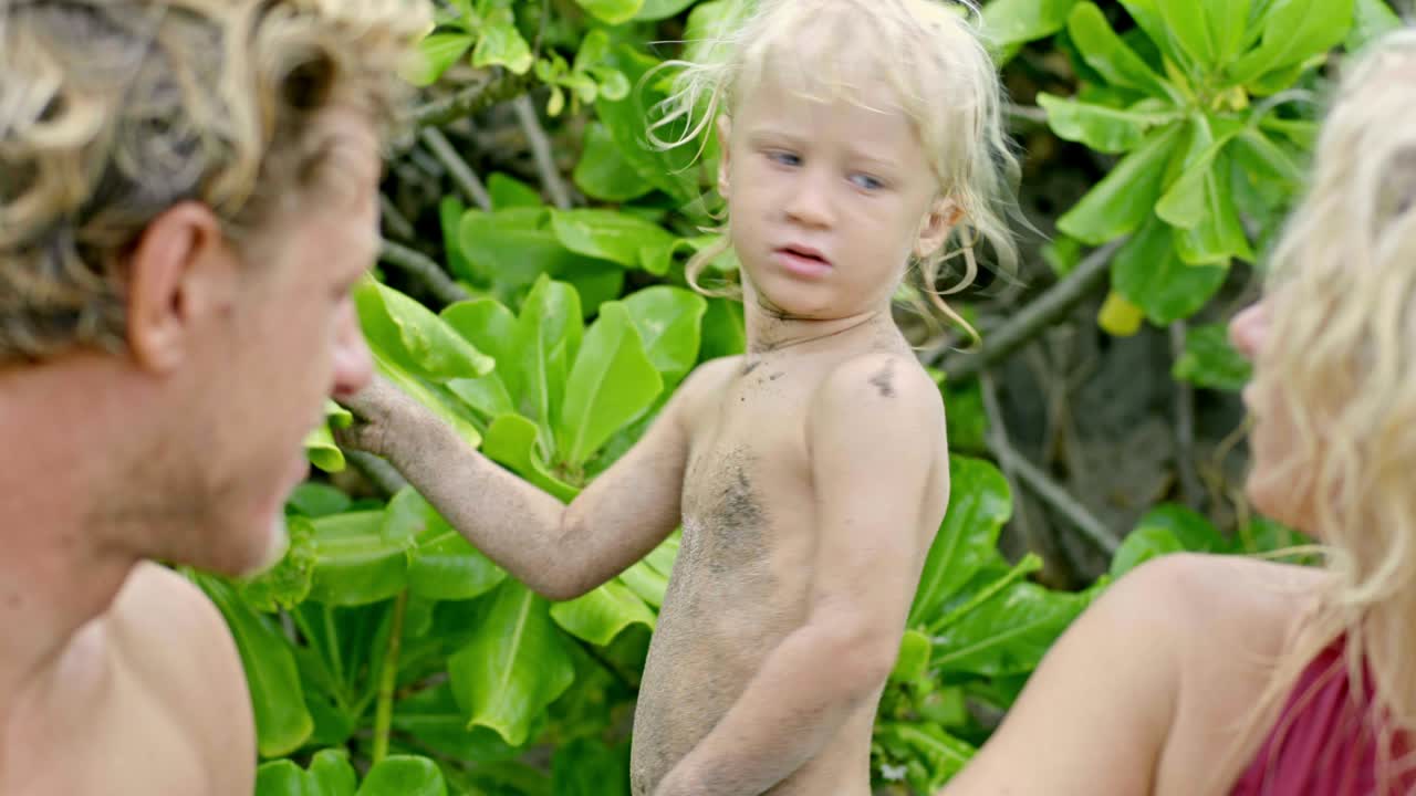 행복 한 아들 과 부모 가 열대지방 에서 휴가를 즐기고 있다