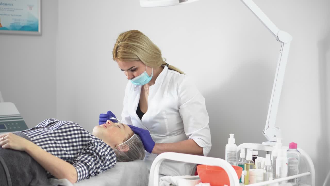 procedimiento de hardware en cosmetología. peeling, fonoforesis, masaje y estiramiento facial en una clínica de belleza. el cosmetólogo suaviza las arrugas con microcorrientes.