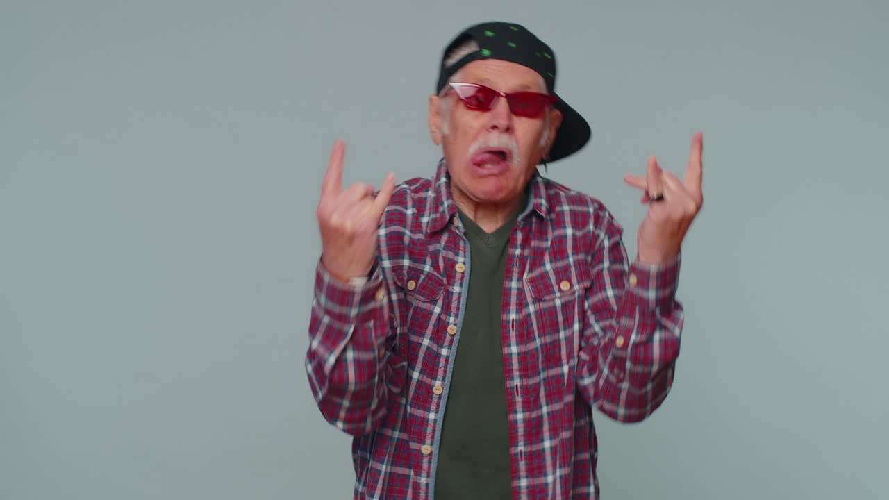 Uomo felicissimo che mostra il gesto del rock 'n' roll con le mani, un segno figo, urlando "yeah" con un'espressione euforica.