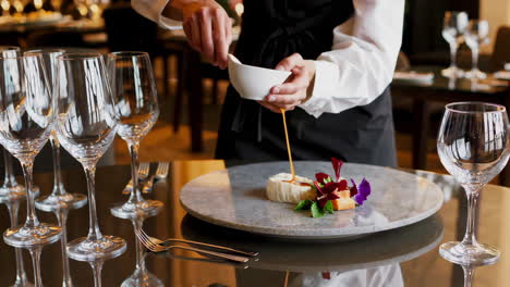 waiter serving gourmet food in an upscale restaurant