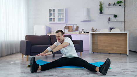 caucasian during workout at home. young man doing slopes and exercising in living room at home during the quarantine
