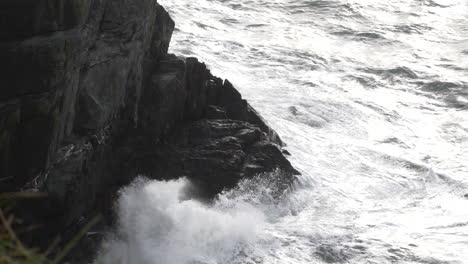 ocean waves crashing into dramatic rocky shore