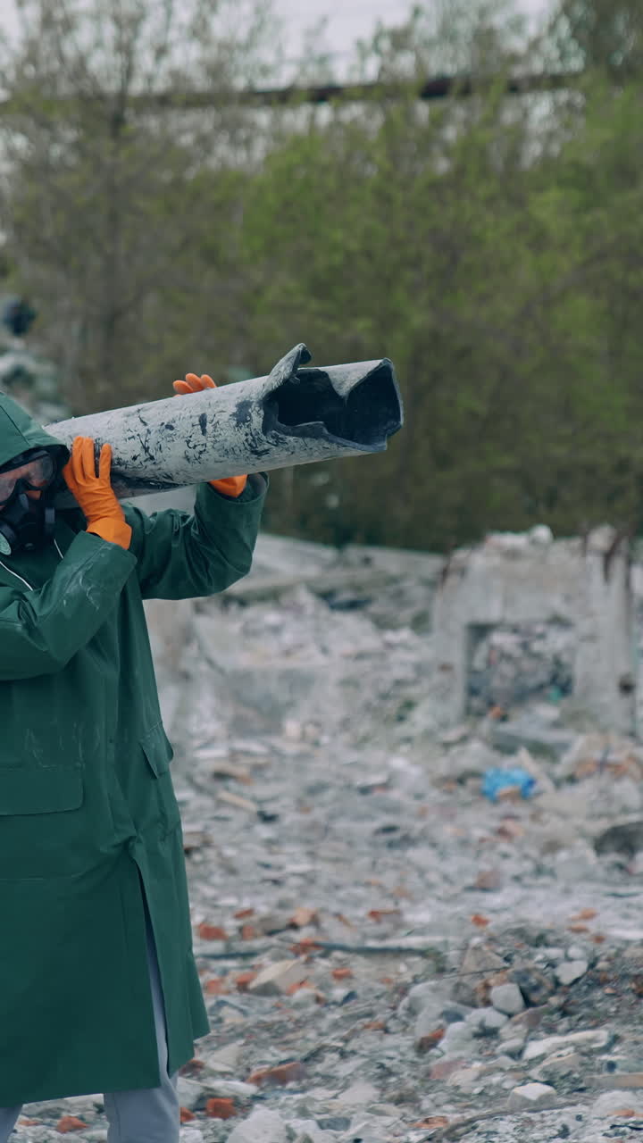 Person in gas mask on ruins. Man in protective clothing and gas mask walking through the ruined city