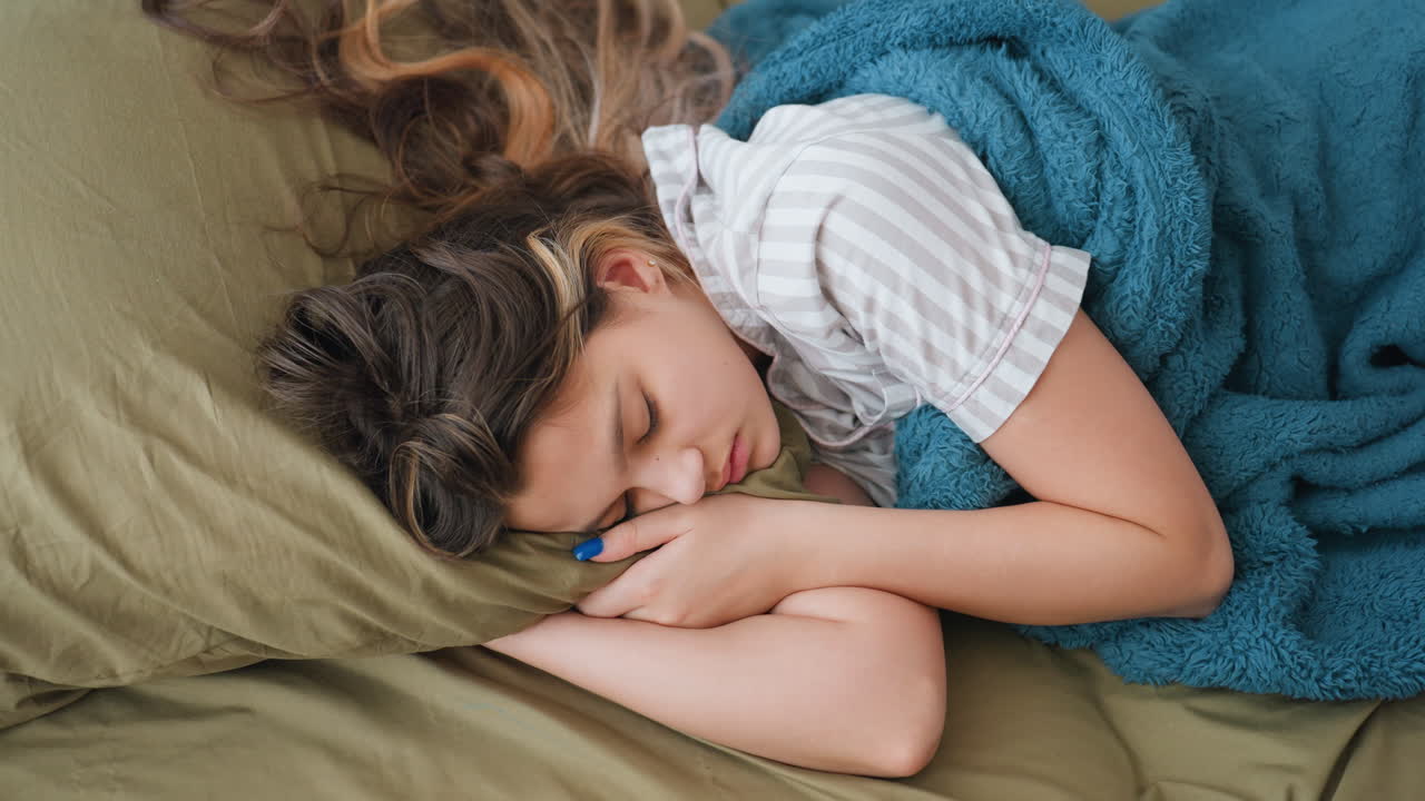 Teen Girl Resting Peacefully Indoors, Comfortable Young Female Lying On Bed With Gentle Light, Young Woman In Sleep Under Calming Teal Blanket With Tranquil Surroundings And Serene Mood