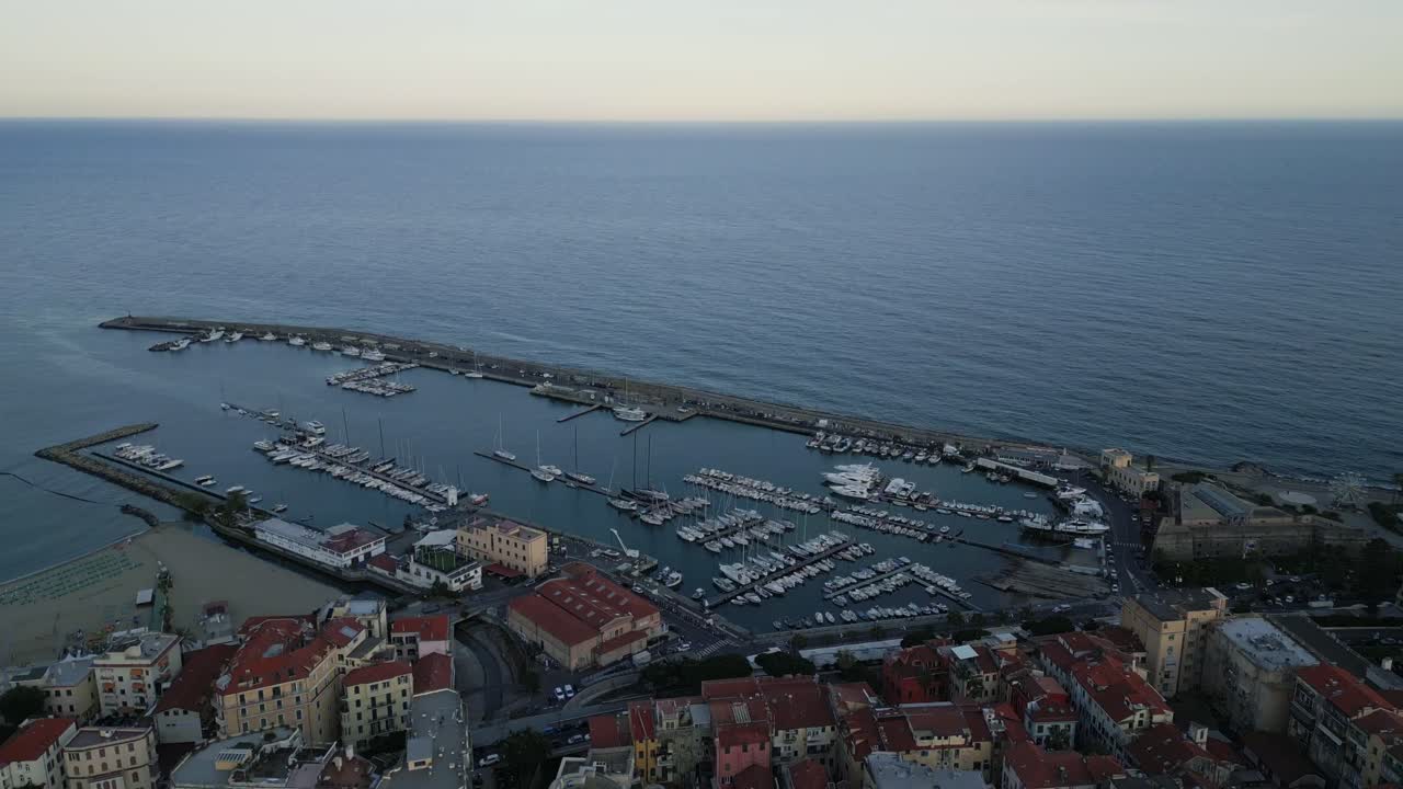 sanremo, italia, puesta de sol vista aérea del mar y el puerto con un yate amarrado en la bahía