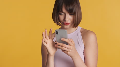 mujer morena sonriente usando un teléfono inteligente