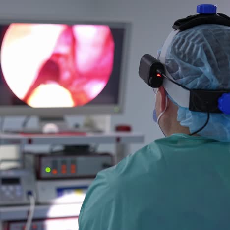 two surgeons performing operation in the surgery room. male doctor looks at the monitor. surgeon checks the patient's organs condition on the screen with the help of hi-tech equipment