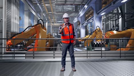 full body of angry asian male engineer with safety helmet shouting at someone while standing with industrial robotic arms working