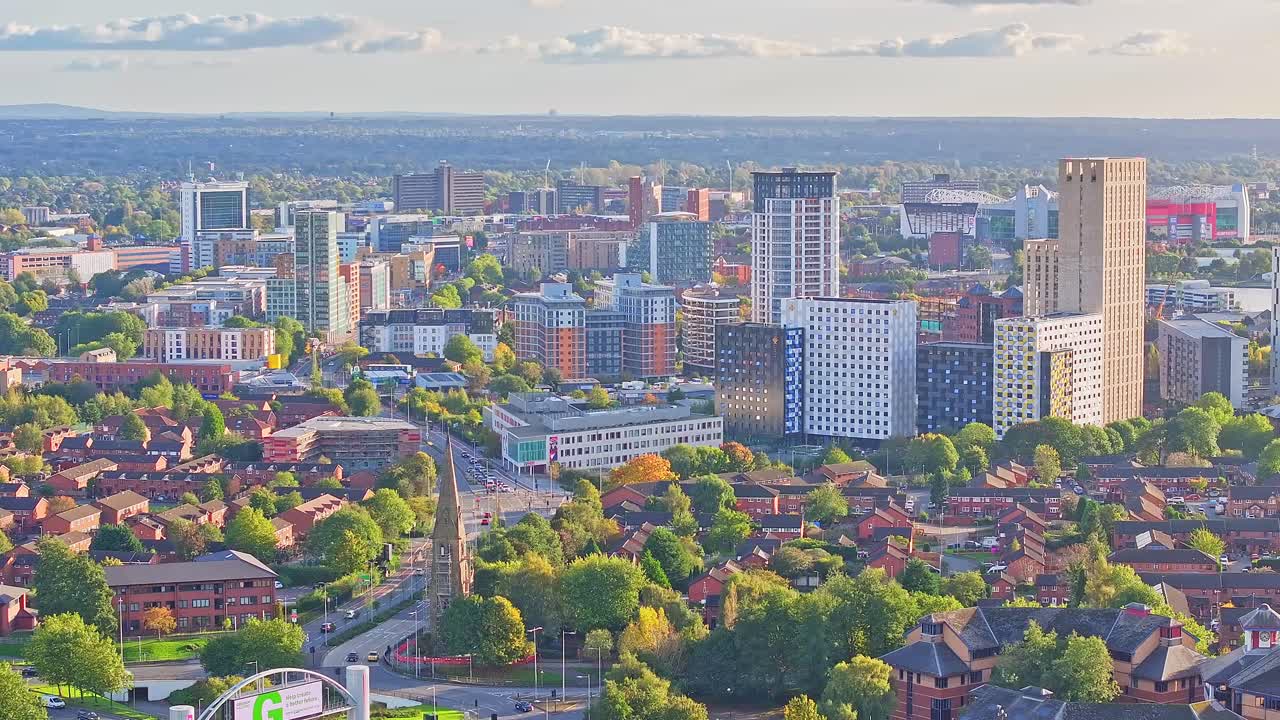 Aerial view of City of Manchester with tower buildings and church with traffic in road during sunny day - Landing flight