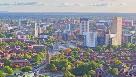 Luftaufnahme-Der-Stadt-Manchester-Mit-Turmgebäuden-Und-Kirche-Mit-Verkehr-Auf-Der-Straße-An-Sonnigen-Tagen---Landungsflug