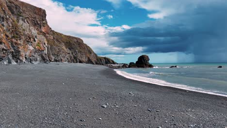 ireland epic drone low flying along deserted stoney beach just before rain shower at sea copper coast waterford ireland in summer