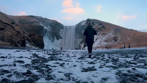 a boy taking a photo of skogaffos in iceland