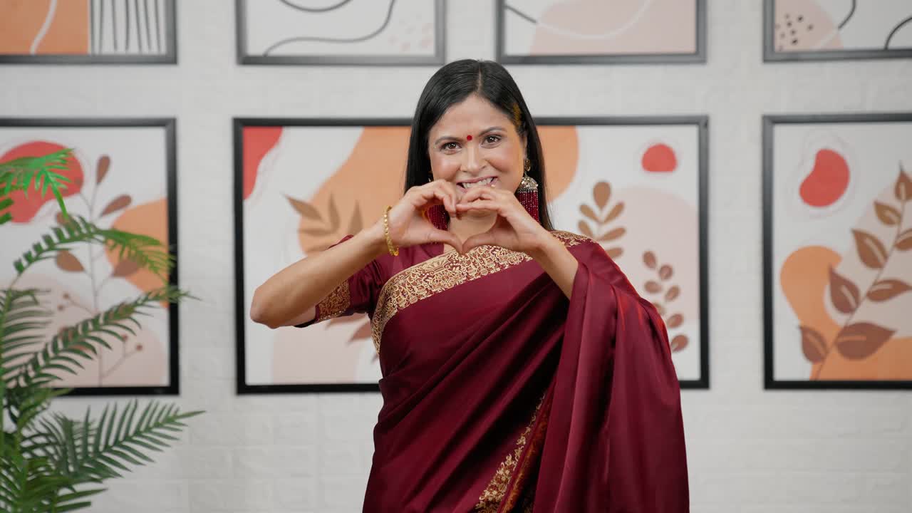 mujer india haciendo el signo del corazón