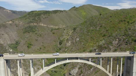 drone flies backwards to reveal bixby creek bridge in big sur, california on highway 1