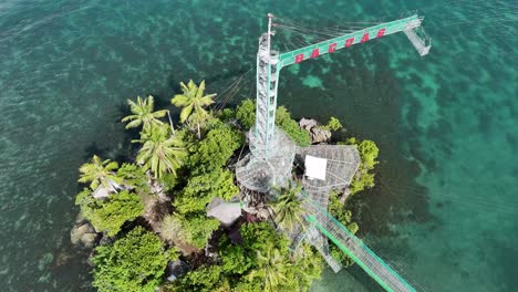 an aerial drone shot of octopus islet ecological adventure park in bacuag, philippines on a bright day with crystal clear turquoise ocean all around