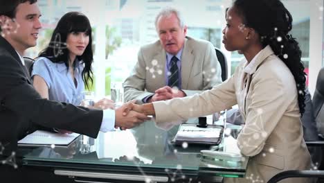 Animation-of-molecules-over-business-people-shaking-hands-in-meeting