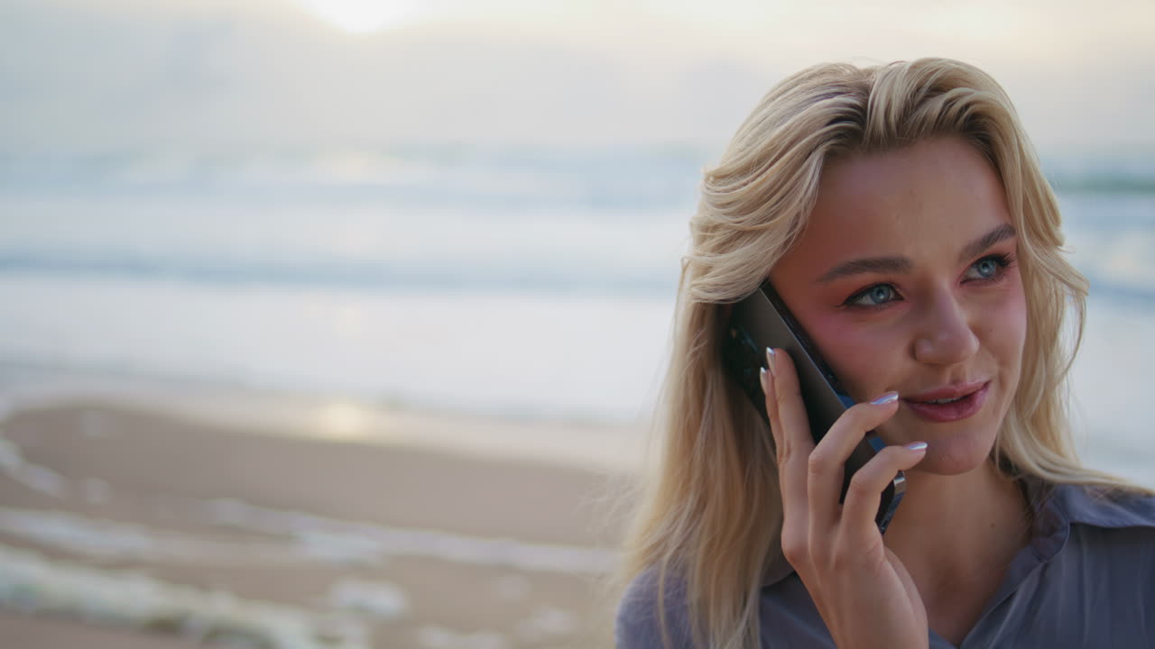Happy girl calling beach using mobile phone closeup. Smiling model resting shore