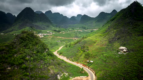 stunning aerial view of winding road through lush green mountains and village in vietnam