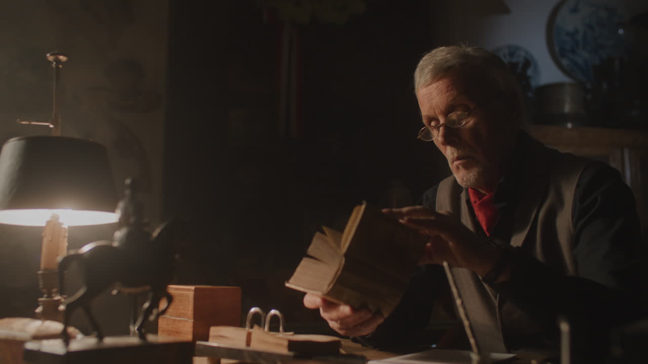 Old passionate man read a book in his office at night