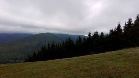 a panning shot of summer landscape in mountains and the dark blue sky with clouds in morning