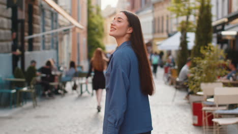rear view of young woman tourist walking through the street outdoors looking searching for a way