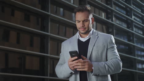 hombre de negocios escribiendo en un teléfono inteligente en la calle