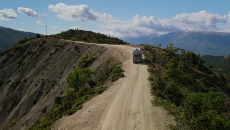imágenes de drones de una autocaravana conduciendo por un sendero de tierra en la cordillera de trebeshinë-dhëmbel-nemërçkë hacia permet, albania