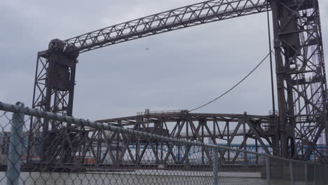 vertical lift style bridge in the cleveland flats on the cuyahoga river, ohio through chain link fence